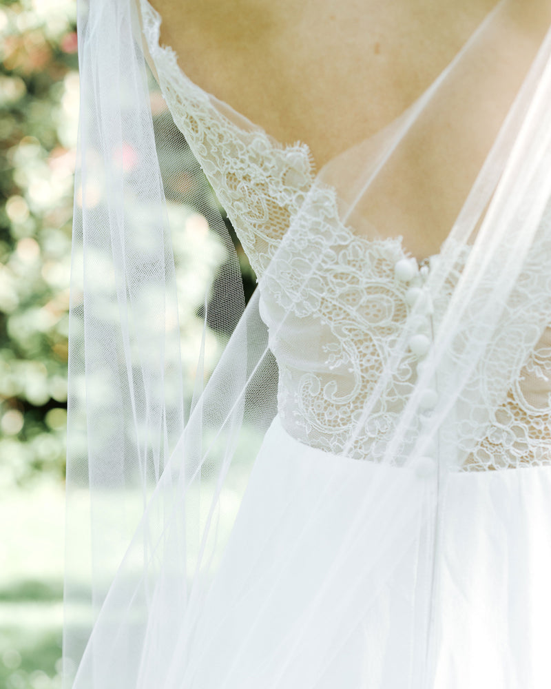 A close view of how the Aster Cape Veil drapes in the back to show the details on the dress beneath.