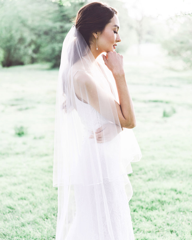 Model wearing calla long bridal veil with blusher