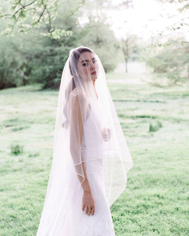 shot with veil model wearing calla bridal veil with ribbon edge and blusher