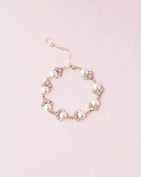 Flatlay view of the Celestial Pearl Cluster Bridal Bracelet in gold with cream pearls.