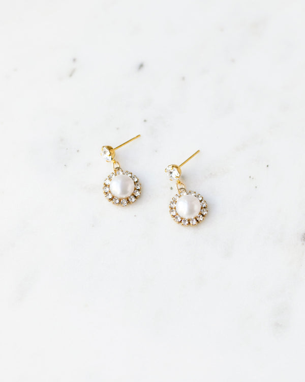 Flatlay photo of the Halo Pearl Drop Bridal Earrings in gold with freshwater pearl.