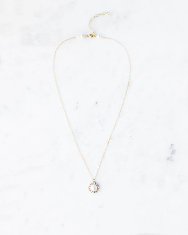 Flatlay photo of the Halo Pearl Drop Necklace in gold with freshwater pearl.