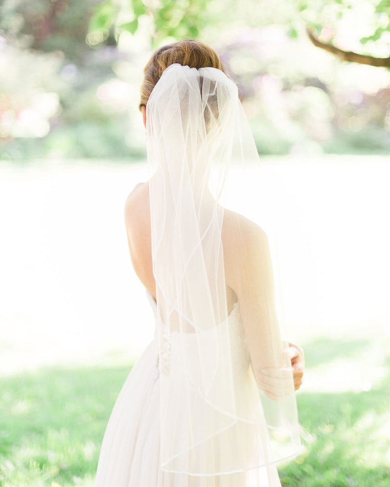 Model wearing short veil with delicate 3/8" satin ribbon edge