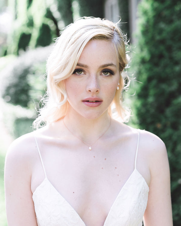 A bride wears the Teardrop Pearl Bridal Necklace in rose gold.