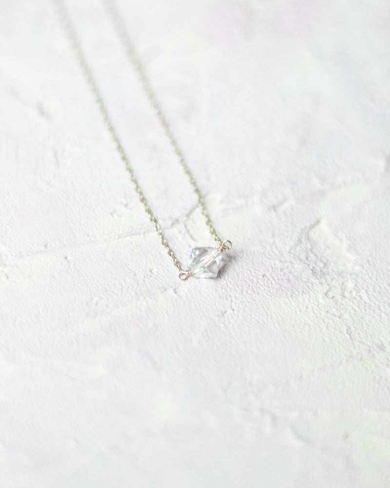 Close flatlay of the Prism Bridesmaid Necklace in silver/crystal.