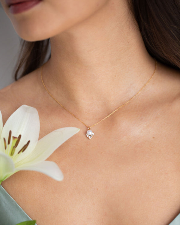 A bridesmaid wears the Celestial Petite Drop Necklace in gold with freshwater pearls.