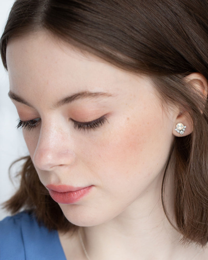 A bridesmaid gazes down as she models our Celestial Crystal Cluster Earrings in silver with white opal crystals in 6mm (petite) size.