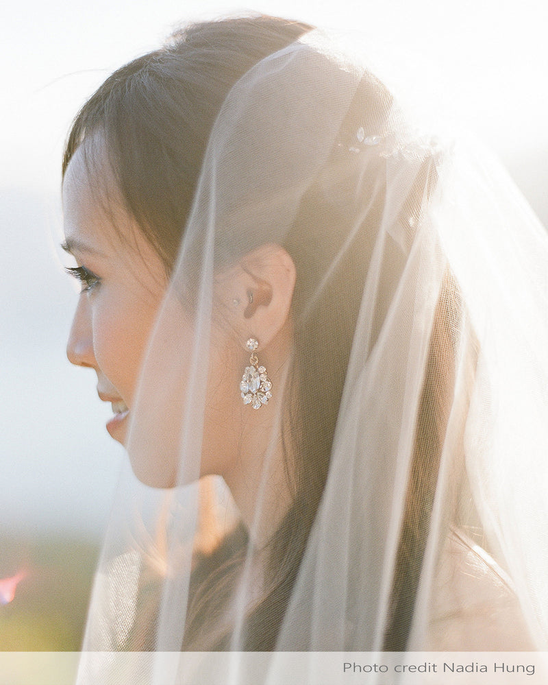 A bride wears the Petite Crystal Drop Earrings in gold.
