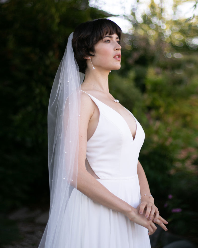 A bride wears the Akina Veil in light ivory.