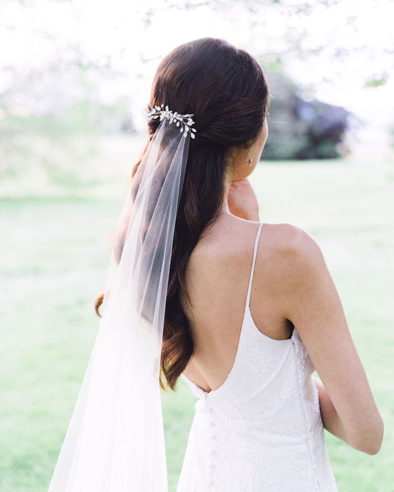Model with a half-up hairstyle wearing a crystal bridal hair comb over the Senna Lace Veil.