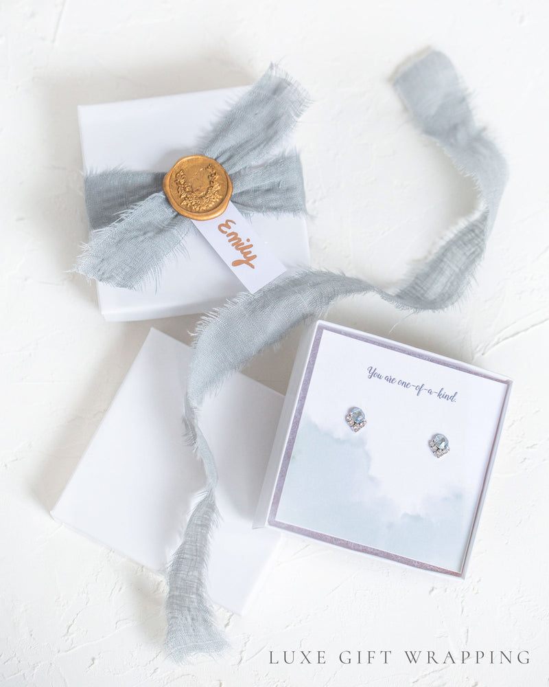 An example of our Luxe gift wrapping, with wax seal, silver linen ribbon, and a custom message.