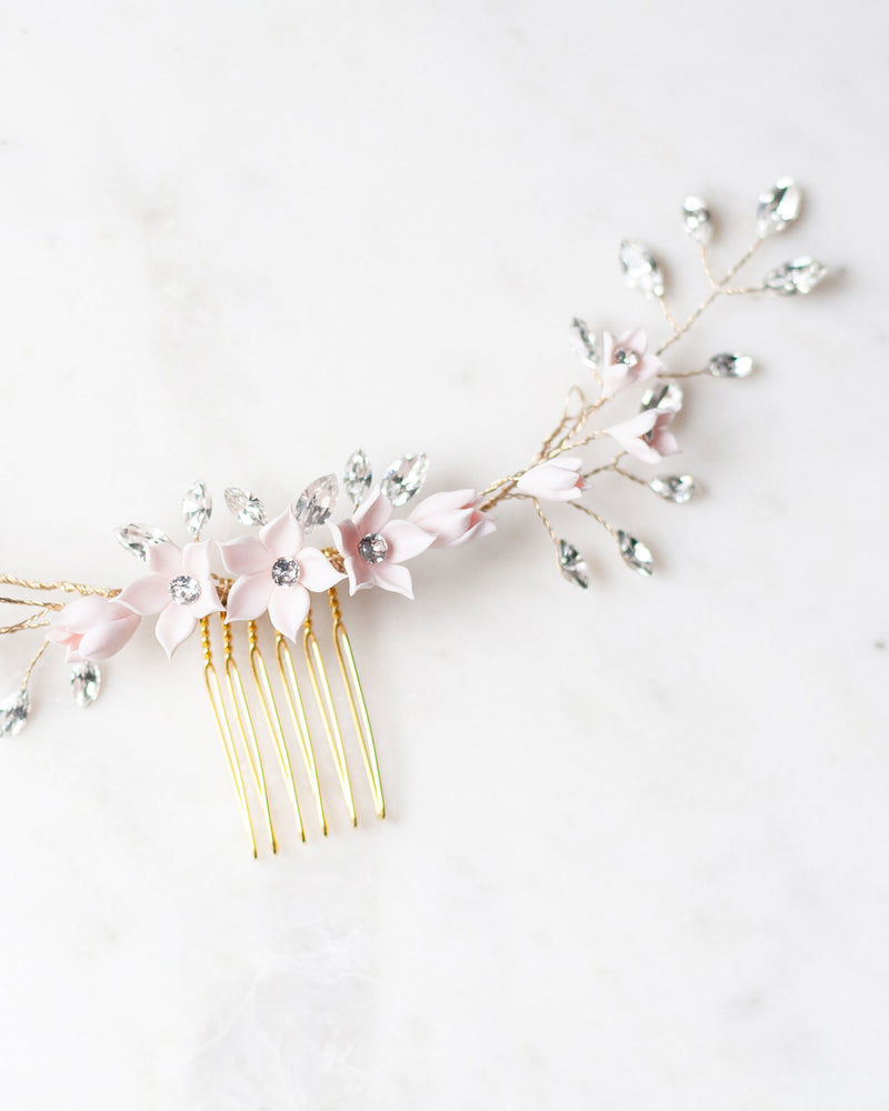 A flatlay view of the Belle Fleur Grand Comb in gold, highlighting the delicate blush flowers and crystals