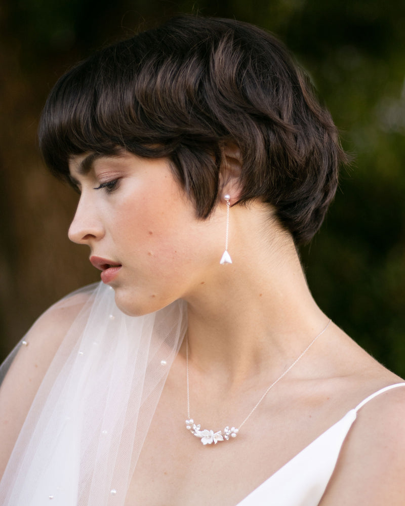 A bride models the Belle Fleur Necklace in silver with ivory flowers.