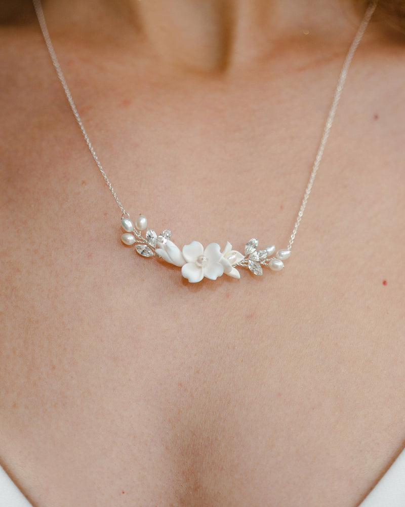 Close model view of the Belle Fleur Necklace in silver with ivory flowers.