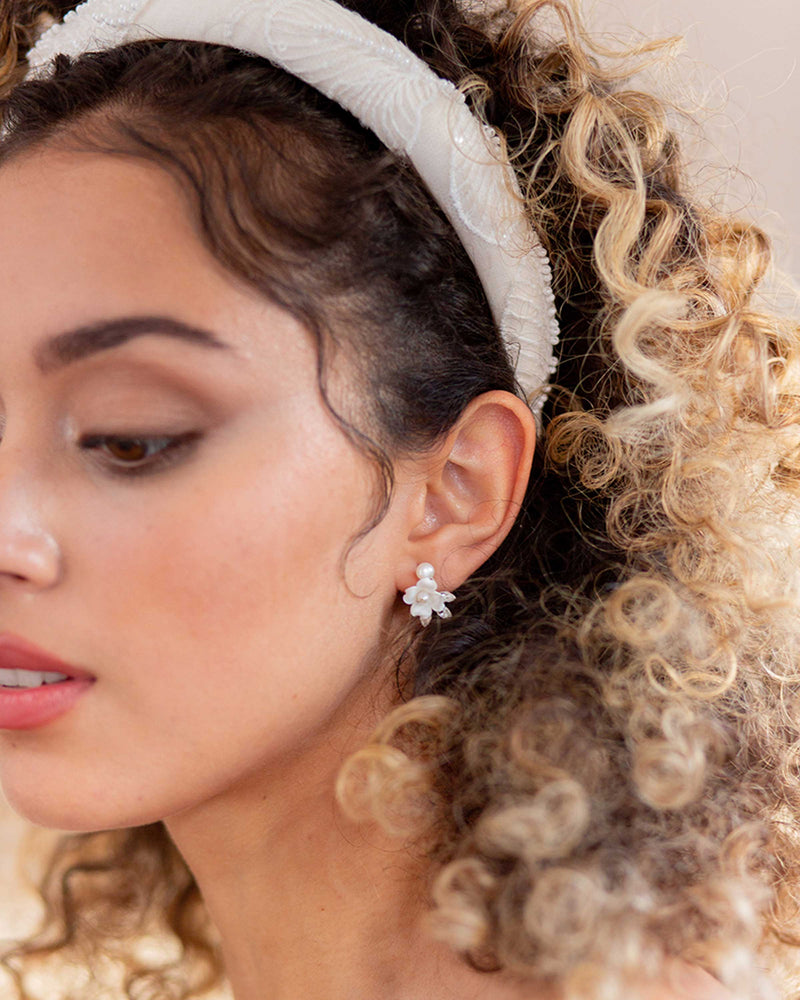 A model wears the Camellia Padded Headband and Belle Fleur Cluster Earrings.