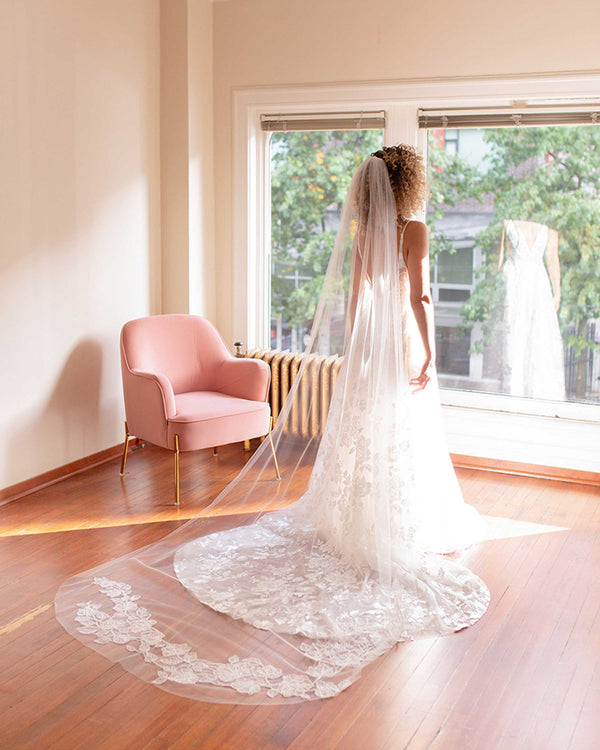 A back view of a bride wearing the Camellia Luxe Lace Veil in extended chapel.