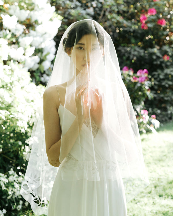 Model wearing cascading leaves tulle wedding veil
