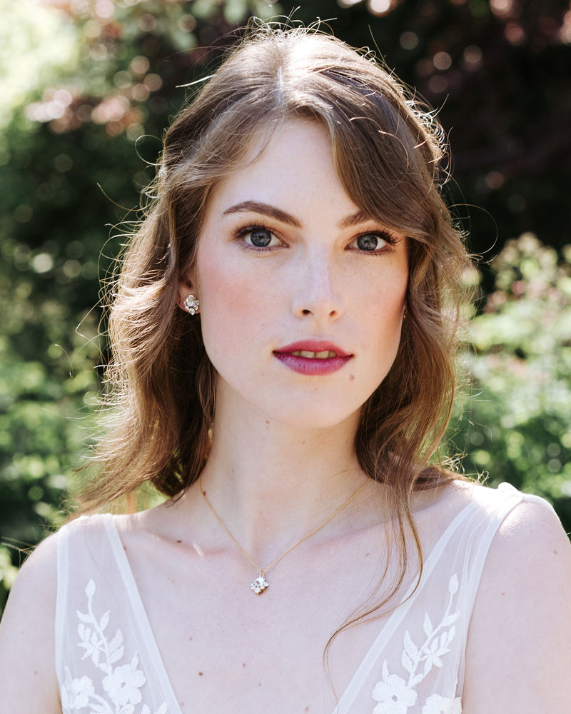 A model with auburn hair wears the Celesetial Crystal Jewelry Set with a crystal drop necklace and stud earrings in gold, with all crystal.