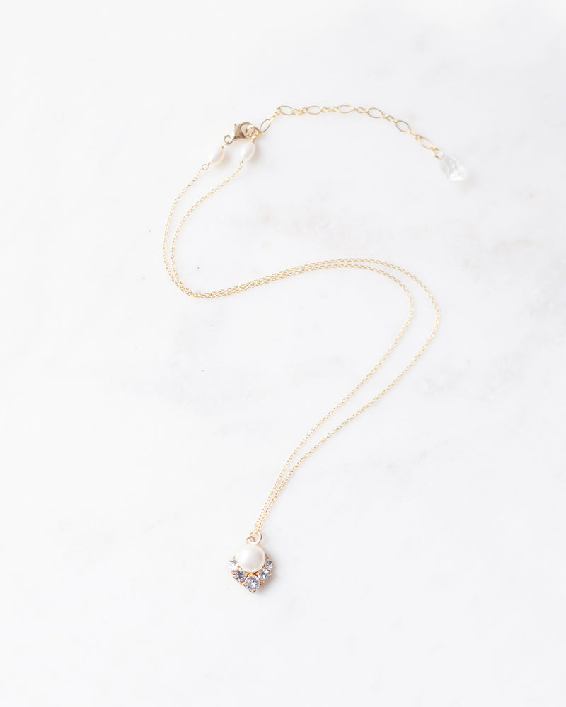 A flatlay view of the Celestial Pearl Drop Necklace in gold with a natural freshwater pearl.
