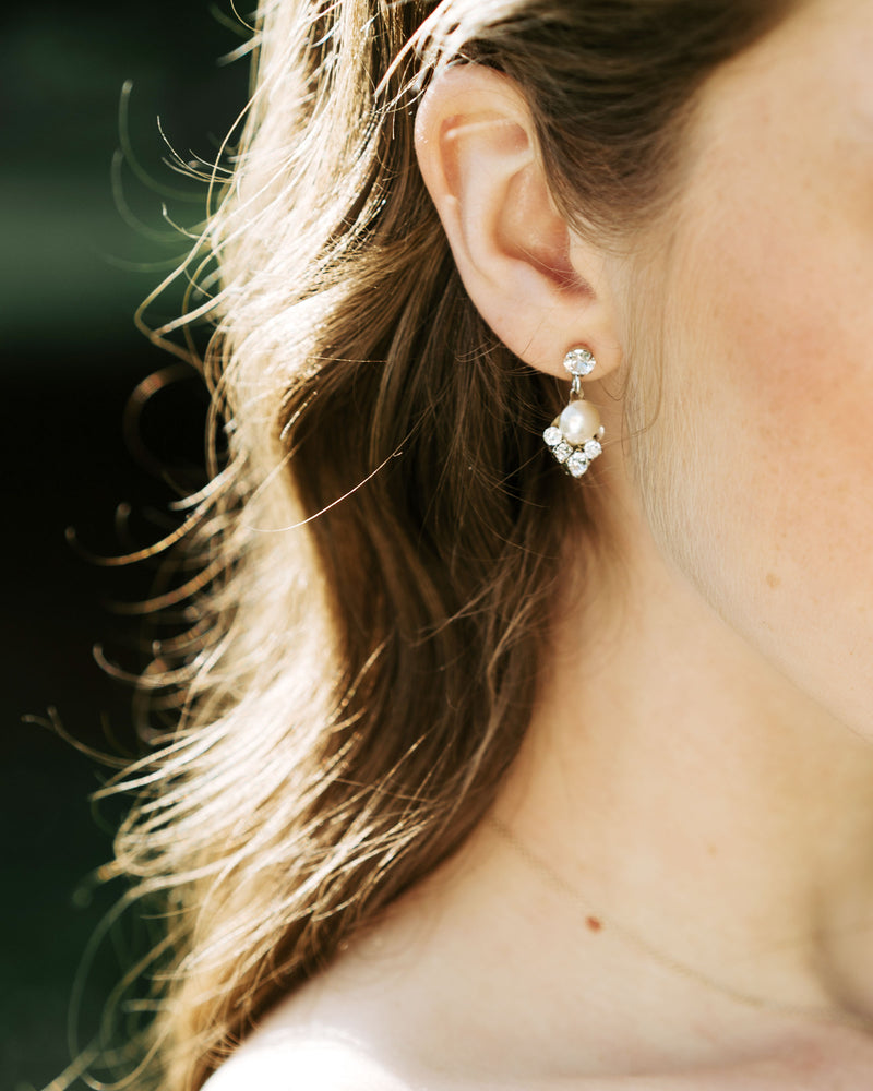 A close model view of the Celestial Pearl Drop Earrings in silver with cream pearls.
