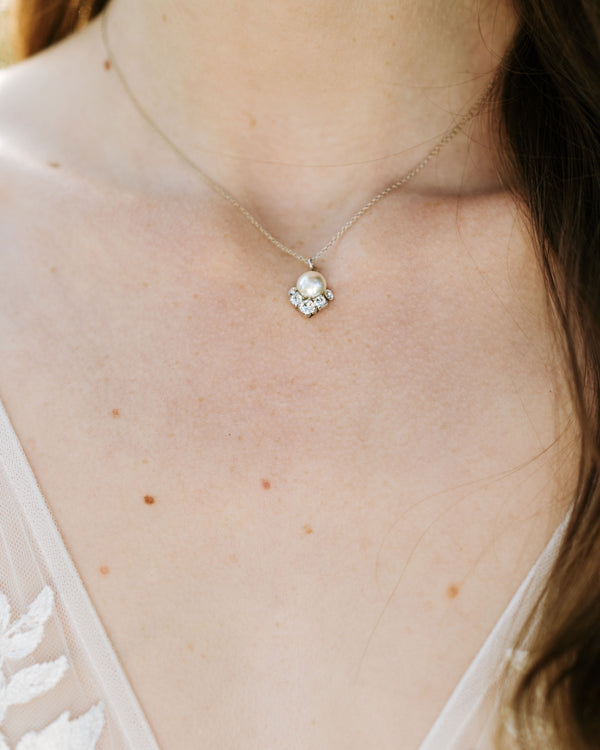 A close model view of the Celestial Pearl Drop Necklace in silver with a cream pearl.