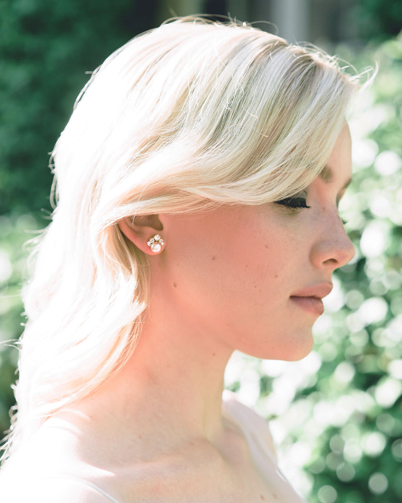 A bride wears the Celestial Stud Earrings in gold with blush freshwater pearls.