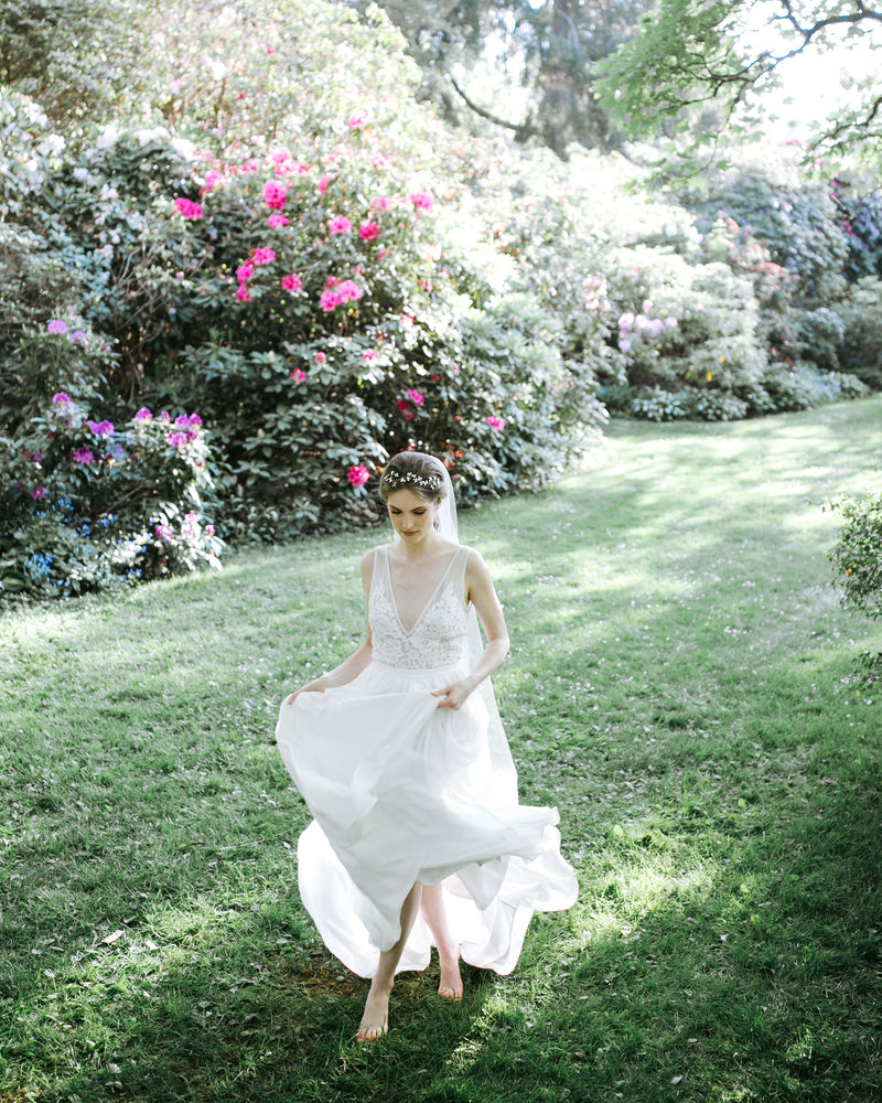 A model runs in the grass at Aberthau Mansion. She is wearing a dramatic crystal hair vine and flowing tulle veil.
