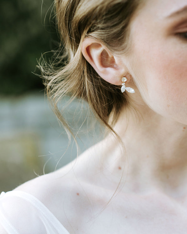 A close model view of the Crystal Leaf earrings in gold.