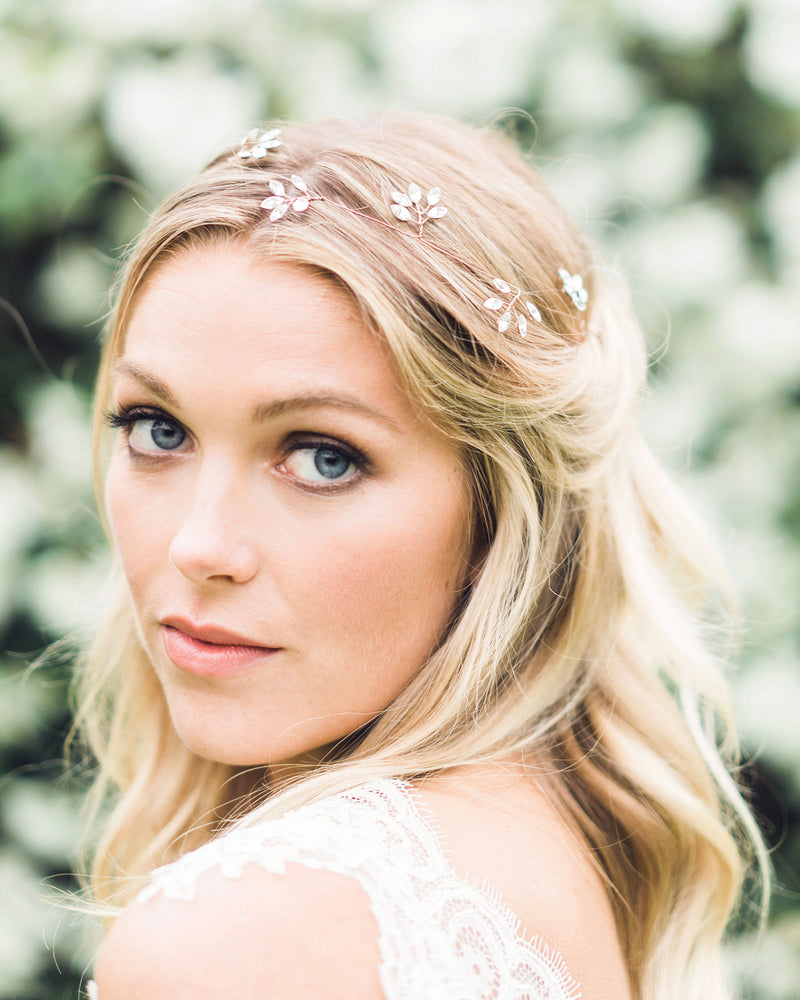 A model wears a delicate hair vine of crystals shaped into sparkling leaf clusters.