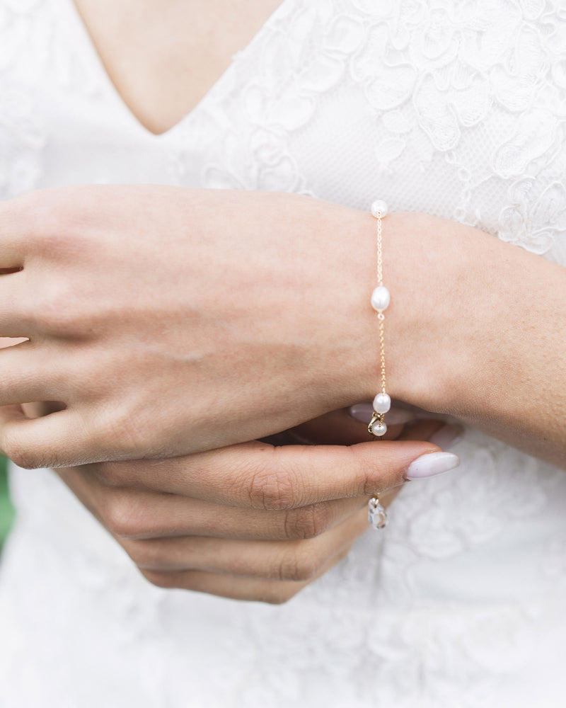 A close view of a model wearing the dainty freshwater pearl bridal bracelet in gold.