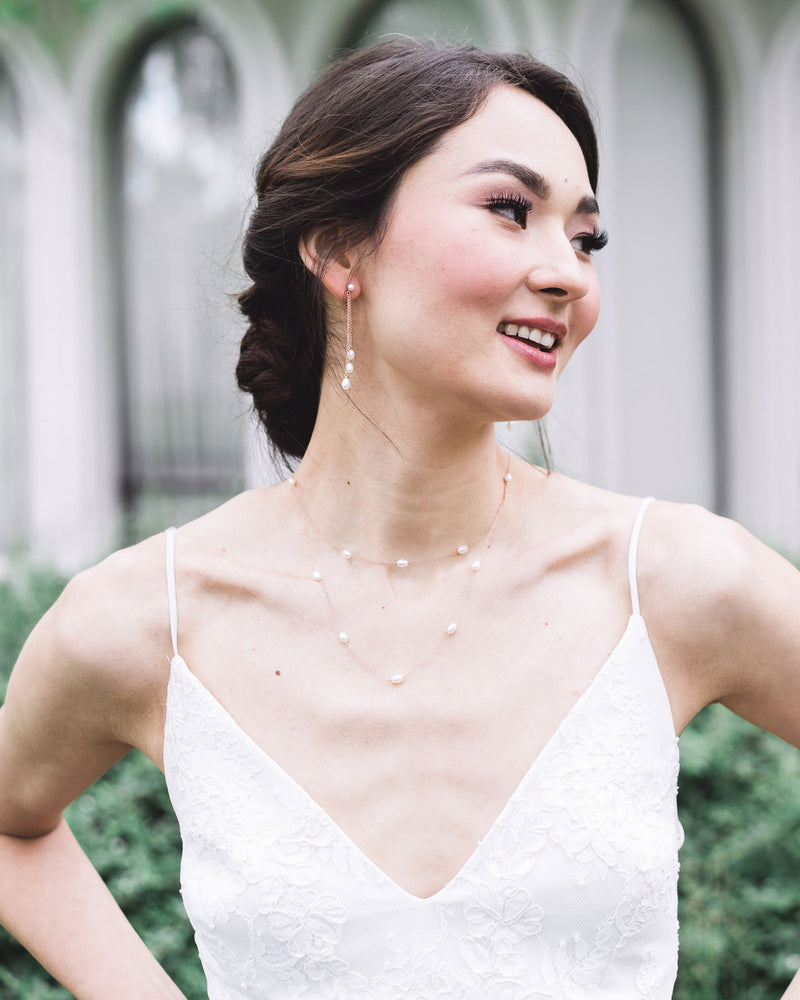 Model wearing the dainty pearl layered necklace in rose gold, paired with the matching dainty pearl trio earrings.