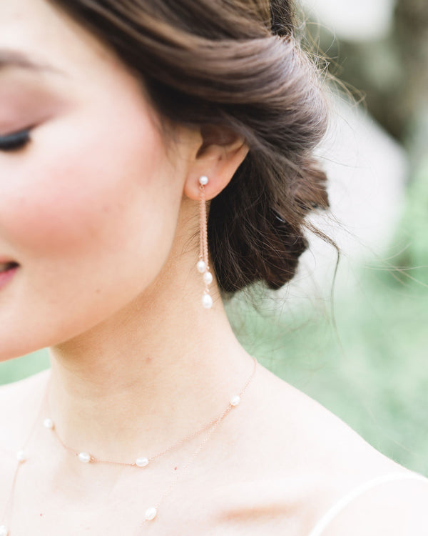 Close up on model of the Dainty Pearl Trio Earrings in rose gold, paired with the Dainty Pearl Layered Necklace.