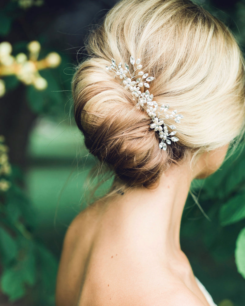 Close model view of a pair of Delicate Combs styled into a modern bridal French twist. The combs are silver with pearls and crystals.