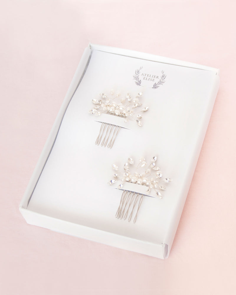 Set of two delicate combs with freshwater pearl flowers and crystals in silver. Prettily packaged in a white jewelry box.
