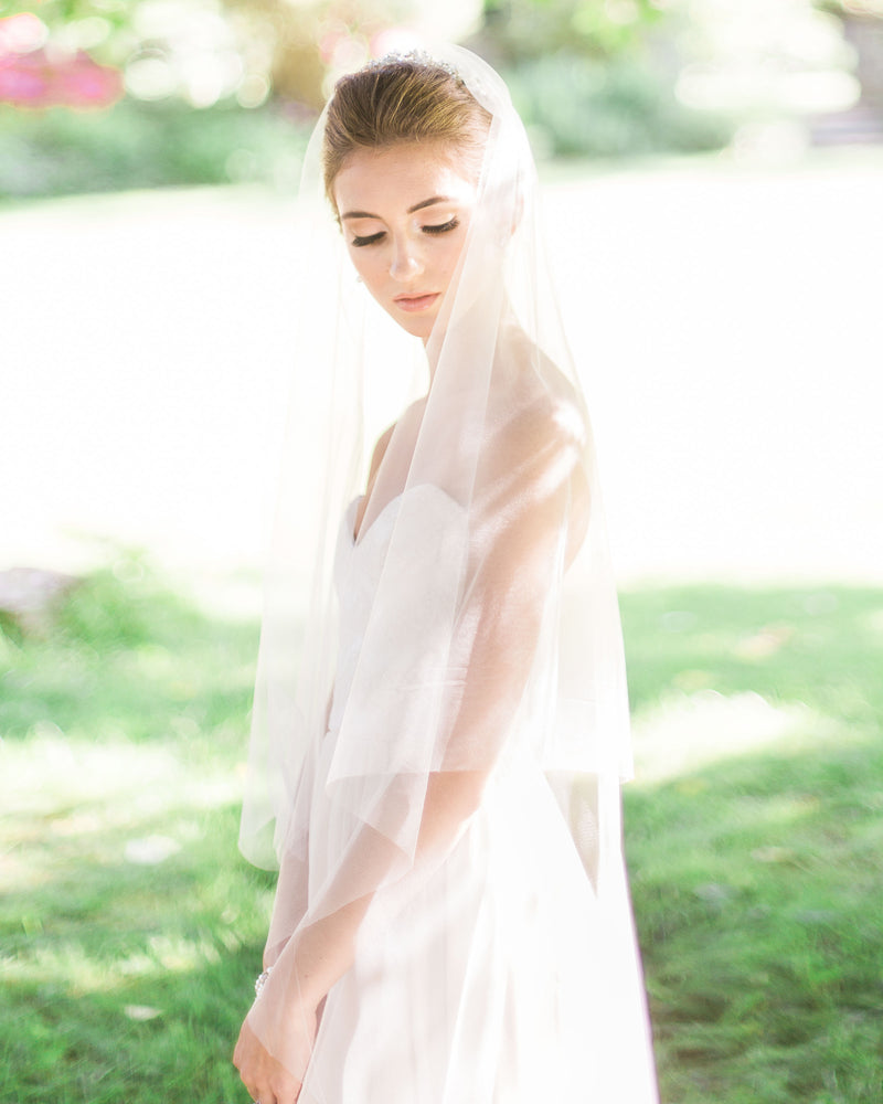 Model wearing circular cut fingertip wedding veil without gathers
