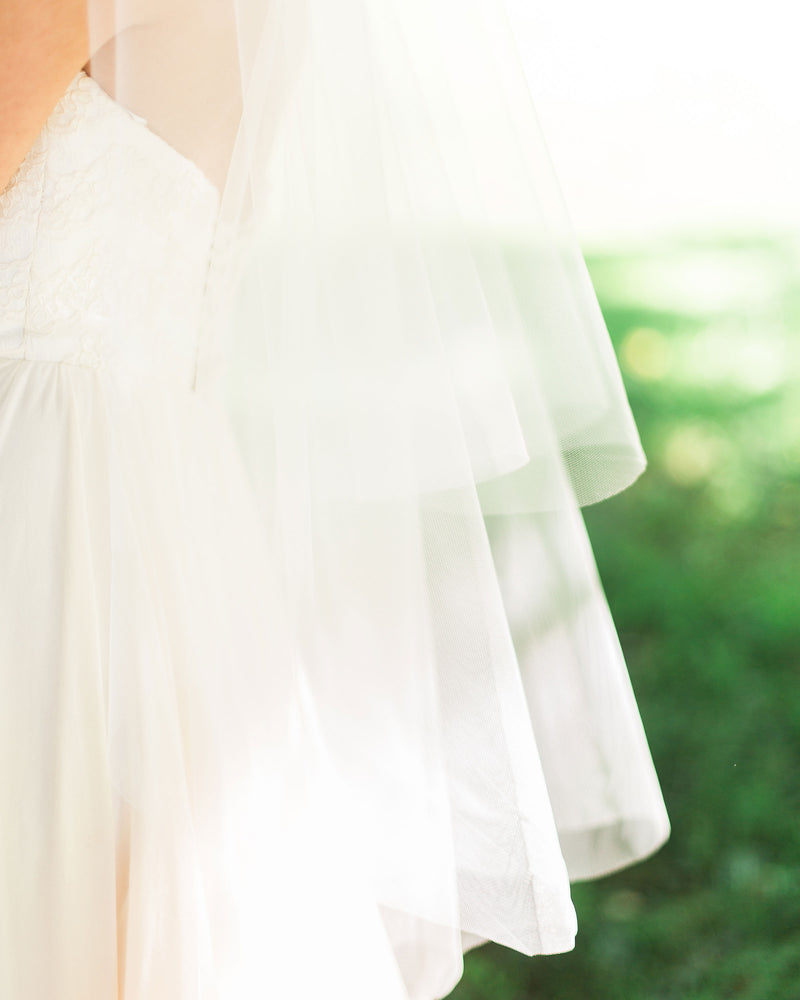 A model close-up of the hand cut edges of our Delphine two-layer veil.