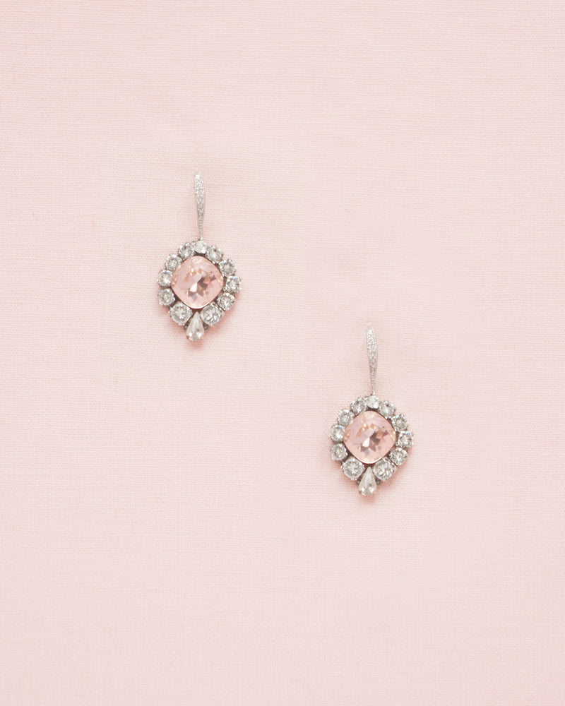 Flatlay of the Enchanted Crystal Drop Earrings in silver with blush crystal centers. The pave crystal hook version is shown.