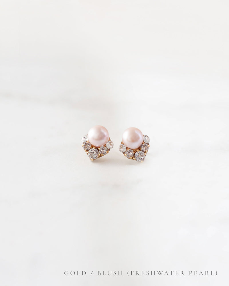 A closeup product view of the Celestial Pearl Cluster Earrings in gold with blush freshwater pearls.