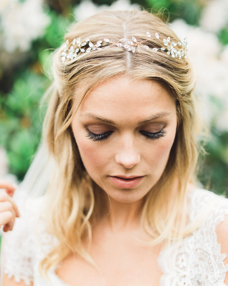 A bride wears her hair in soft waves with both sides pinned back. The Everthine Hair Vine is styled at the front; sprays of crystals in an asymmetrical design.