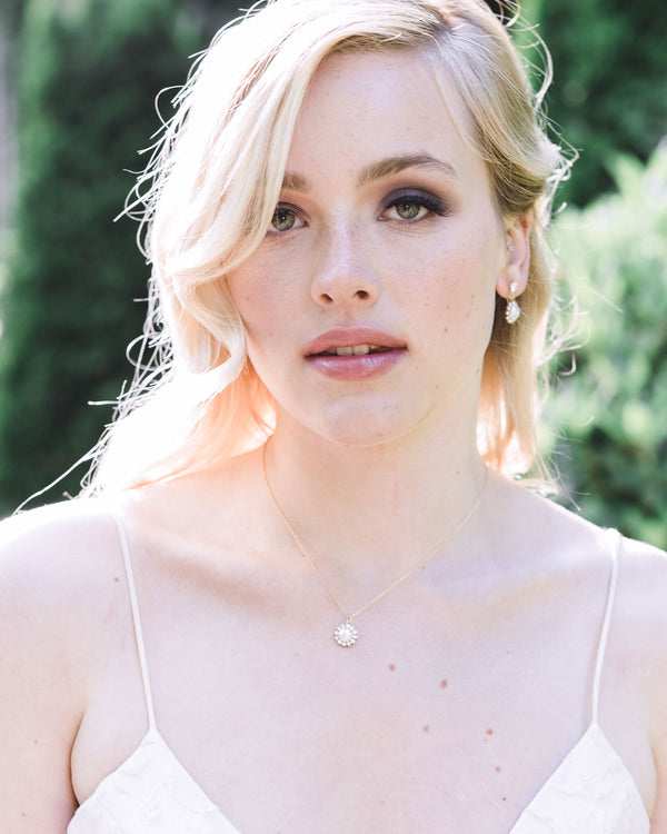 A model with blonde hair styled in bridal waves wears the Halo Pearl Drop Jewelry Set in gold with freshwater pearls.