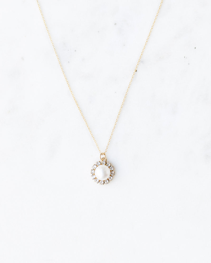 Close up view of our delicate bridal necklace with a pearl drop surrounded by a halo of crystals.