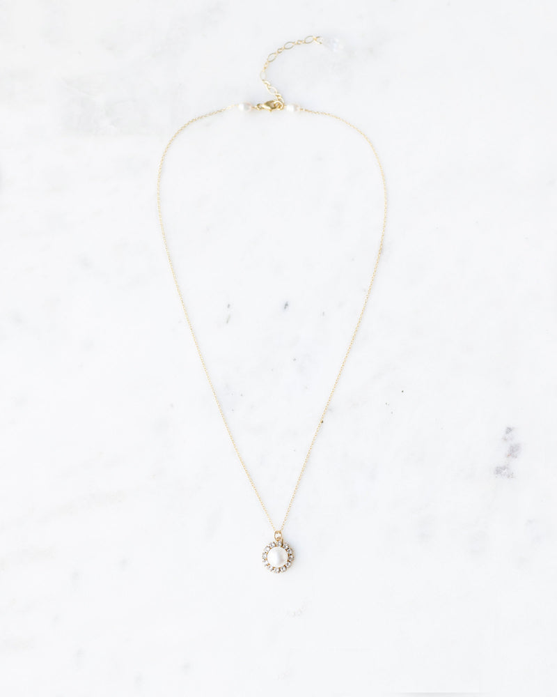 Flatlay photo of the Halo Pearl Drop Necklace in gold with freshwater pearl.
