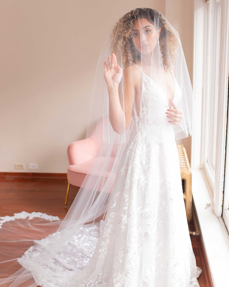 A bride wears the Hibiscus Circular Lace Veil with blusher styled to the front.