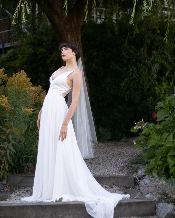 A bride models the Iris Luxe Pearl Veil in fingertip length.