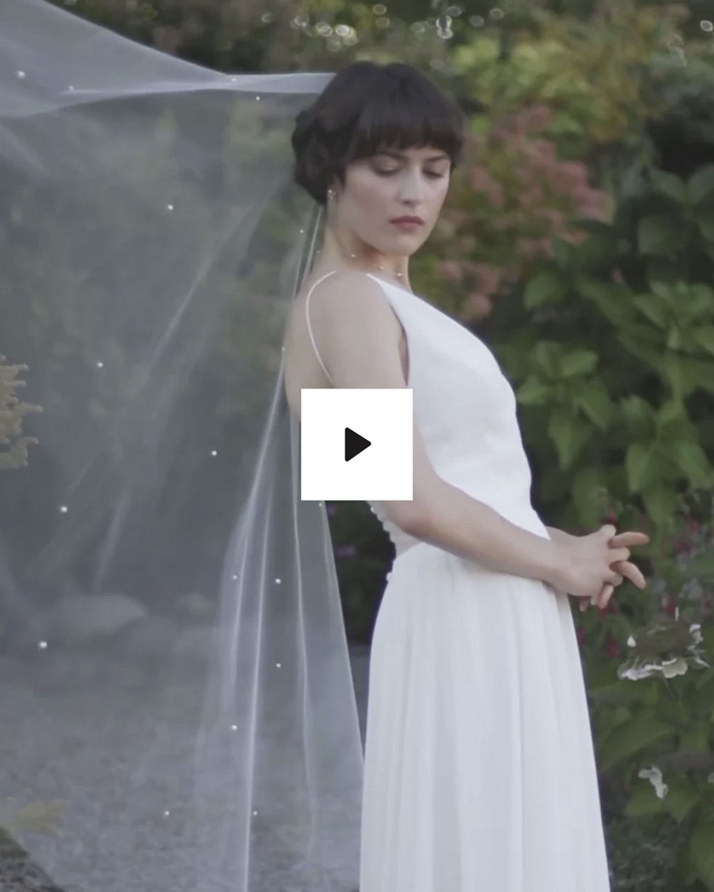 A bride models the Iris Luxe Pearl Veil in fingertip length.