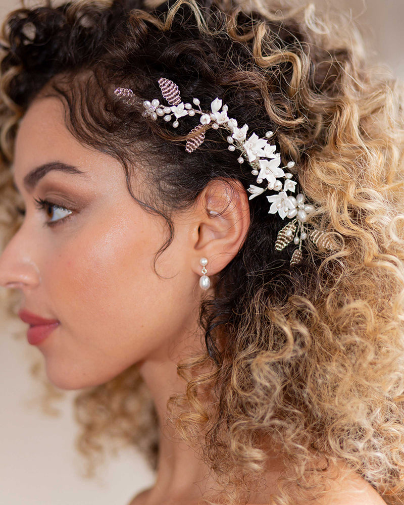 A bride wears the Lily Floral Comb and the Teardrop Pearl Petite Earrings.