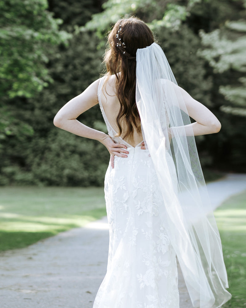 A back view of a bride wearing a waltz length veil with no trim.