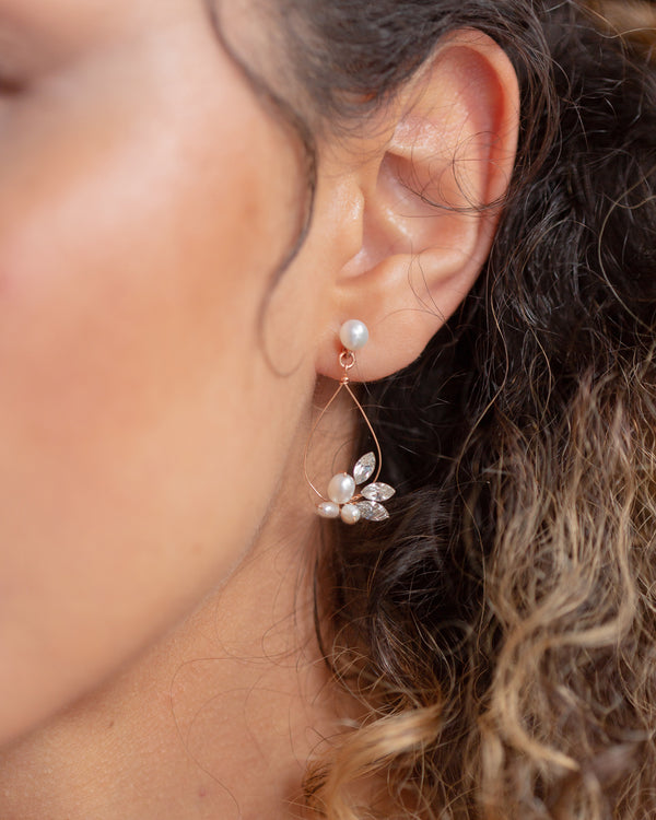 A close model view of the Lovely Pearl Earrings in rose gold.