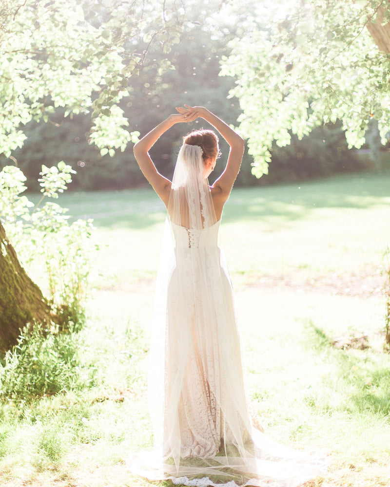 A back view of a bride waring the Magnolia Lace Veil in chapel length.