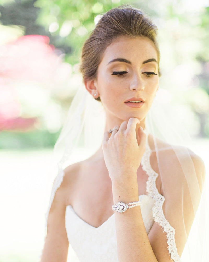 A close view of the Alencon lace trim on the Magnolia Veil, worn by a bride.